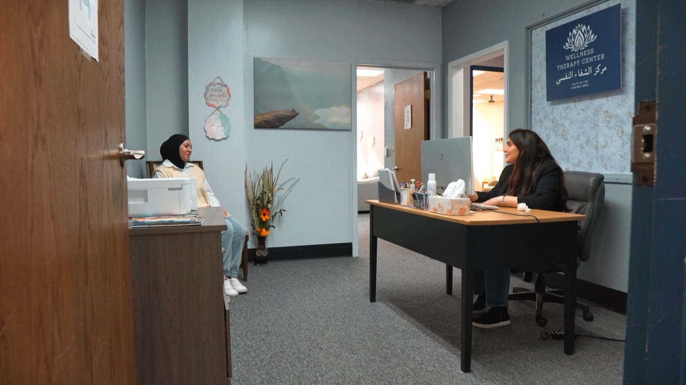 A client talking with a Wellness Therapy Center team member at the front desk of the Dearborn office